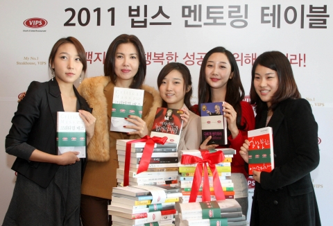 빕스 홍대점에서 진행된 ‘2011 빕스(VIPS) 멘토링 테이블’의 멘토로 초청된 백지연 앵커가 여성 참가자들과 함께 지역사회 공부방 아동들에게 전달 할 기증서적들을 포장하고 있다