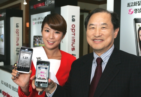 LG유플러스 이상철 부회장과 홍보 모델이 제주도에서 4G LTE 스마트폰과 3G 스마트폰의 다운로드 및 업로드 속도를 비교 시연하고 있는 모습.