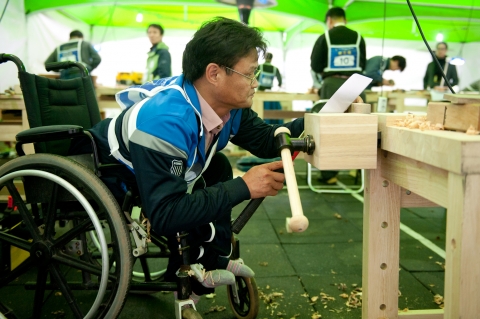 제28회 전국장애인기능경기대회에 출전한 김정수선수가 목공예 작품 제작에 구슬땀을 흘리고 있다.