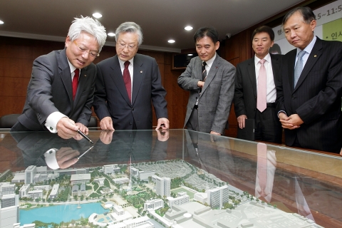 KT 이석채 회장(왼쪽 두번째)과 건국대학교 김진규 총장(맨 왼쪽)이 대학 모형물을 보며 스마트 캠퍼스 구축 방안에 대해 이야기를 나누고 있다.