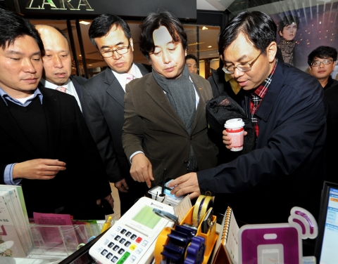 3일(토) 명동 NFC존을 방문한 차이나모바일 경영진이 SK플래닛 이주식 Service Platform BU장(오른쪽 두번째)에게 SK텔레콤의 NFC 서비스의 효용성에 대한 설명을 들으며 체험해보고 있다.