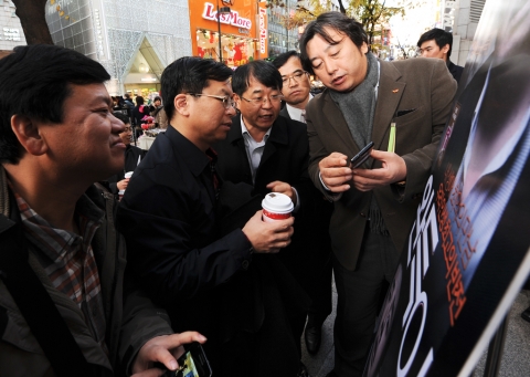 3일(토) 명동 NFC존을 방문한 차이나모바일 경영진이 SK플래닛 이주식 Service Platform BU장(사진 오른쪽)에게 SK텔레콤의 NFC 서비스의 효용성에 대한 설명을 듣고 있다.