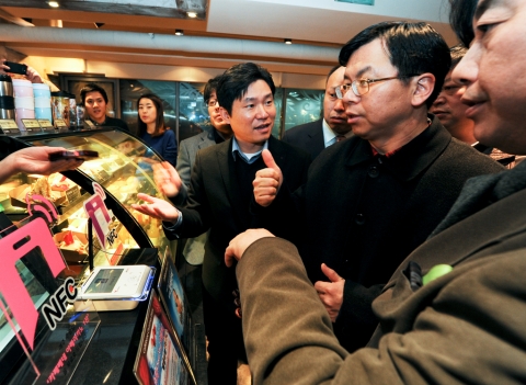 3일(토) 차이나모바일 경영진이 SK플래닛 임직원과 함께 명동 NFC존을 방문해 SK텔레콤의 NFC 서비스를 체험하고 있다.