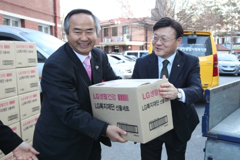 LG복지재단 정윤석 전무(오른쪽)가 서울 마포구 이대성산종합사회복지관에서 한국사회복지관협회 배윤규 회장(왼쪽)에게 LG생활건강의 생활필수품세트를 전달하는 모습.
