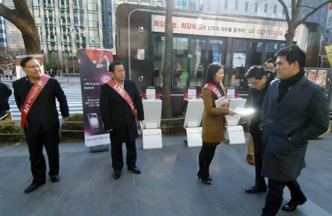 좌측부터 LG전자 경영지원부문장 이영하 사장, 배상호 노조위원장, 직원들이 12월 19일 여의도역에서 시민들에게 옵티머스 LTE 화질의 우수성을 담은 전단지를 나눠주고 있다.