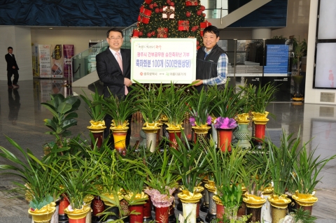 광주시청 이연 총무과장이 아름다운가게 광주전남본부 한상근 간사에게 축하화분 100개(500만원 상당)를 전달하고 있다.