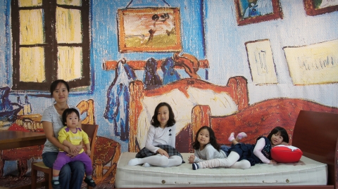 해운대문화회관 제1전시실에 설치된 &#039;트릭포토&#039; 미술관에서 가장 인기가 많은 고흐의 방 에  어린들이 침대에  앉아  즐거워하고 있다.