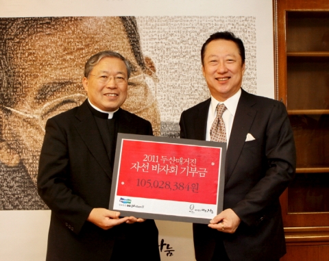 두산매거진 발행인 박용만 ㈜두산 회장(오른쪽)이 2월 17일 서울 중구 명동2가 천주교 서울대교구청에서 재단법인 바보의 나눔 이사장 염수정 주교에게 두산매거진 자선 바자회 수익금 1억 5백여만 원을 전달했다.