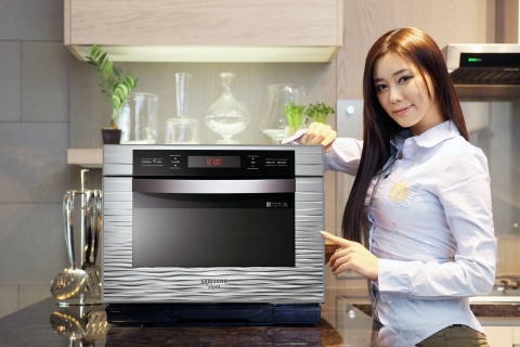 삼성전자가 스마트폰의 어플리케이션을 활용해 식재료 준비와 요리를 한 번에 끝낼 수 있는 지펠 스마트 오븐을 출시했다. 사진은 논현동 삼성 솔루션 전시장에서 삼성전자 모델이 신제품 오븐을 선보이는 모습.