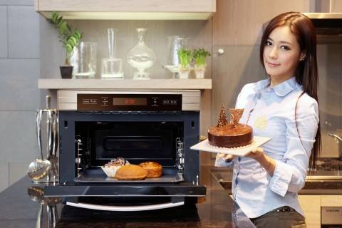 삼성전자가 스마트폰의 어플리케이션을 활용해 식재료 준비와 요리를 한 번에 끝낼 수 있는 지펠 스마트 오븐을 출시했다. 사진은 논현동 삼성 솔루션 전시장에서 삼성전자 모델이 신제품 오븐을 선보이는 모습.