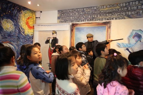 트릭포토 미술관에서 홍연초등학교 학생들이 사진작가 김기춘씨로부터 3D사진 촬영에 대한 현장 강의을 듣고있다