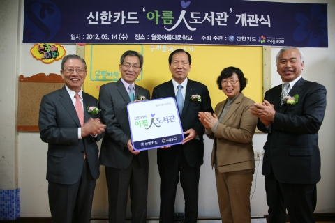 신한카드는 14일 오후 강화도 '월곶 아름다운 학교'에서 송자 아이들과미래 이사장(왼쪽에서 첫번째),김유택 월곶아름다운학교 지역아동센터 대표(왼쪽 두번째), 이재우 신한카드 사장(왼쪽 세번째), 이숙현 국립어린이청소년도서관장(왼쪽 네번째), 조필기 대월초등학교장 등이 참석한 가운데 2012년 첫번째 '아름인 도서관' 개관식을 갖고, 이재우 사장이 김유택 대표에게 현판을 전달하고 있다.