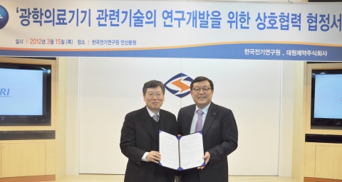 한국전기연구원 김호용 원장(왼쪽)과 대원제약 백승호 회장이 15일 ‘광학의료기기 관련 기술의 연구개발’을 위한 업무협약(MOU)을 체결하고 협약서를 들어보이고 있다.