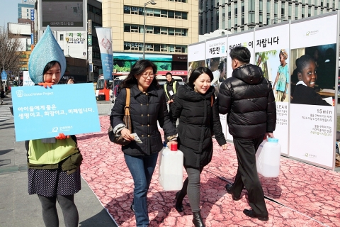 21일(수), 서울 광화문 광장에서 시민들이 국제구호개발 NGO 굿네이버스 주최로 진행된 &#039;세계 물의 날&#039; 캠페인에 참여하여 물부족 국가 현지 아동들처럼 물통을 들고 길을 걷고 있다.