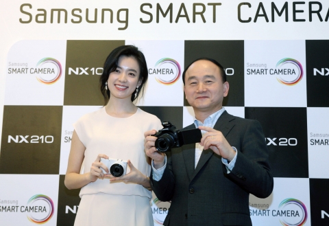 삼성전자 디지털이미징사업부장  한명섭 전무와 삼성 카메라 모델 한효주가 새로운 NX 시리즈를 선보이고 있다.