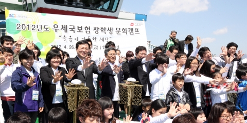 우체국보험 장학생 문화캠프가 26일 서울 여의도 한강공원 유람선상에서 열려 윤상직 지식경제부 차관(왼쪽에서 여섯 번째)과 김명룡 우정사업본부장(왼쪽에서 다섯 번째), 아동-청소년들이 힘차게 손을 흔들고 있다. 이날 지식경제부 우정사업본부는 어려운 환경 속에서도 미래를 꿈꾸는 아동·청소년 100여명에게 우체국 공익형 보험상품인 '청소년 꿈 보험'을 무료로 가입해주는 장학증서를 전달했다. <사진제공 : 우정사업본부>