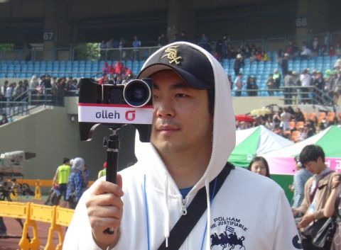 지난 해 5월 열린 &#039;제20회 서울국제휠체어마라톤대회&#039;에서 아이폰을 이용해 잠실올림픽주경기장을 촬영하고 있는 모습.