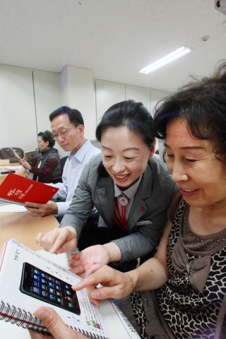서울시 송파구 잠실4동 주민센터에서 KT의 IT서포터즈가 어르신들에게 ‘세상에서 가장 쉬운 스마트폰 설명서’를 설명하고 있는 모습.