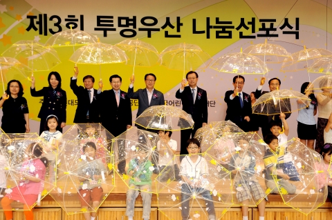 서울시 강남구 개포동 소재 개일초등학교에서 열린 ‘제3회 어린이 교통안전 투명우산 나눔 선포식’에 참석한 행사 관계자들과 어린이들이 함께 투명우산을 들고 기념 촬영을 하고 있다.