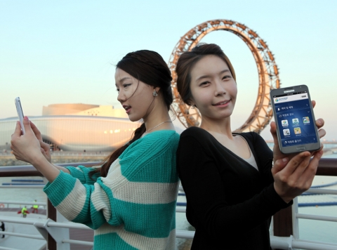 LTE특별구역_1 : 여수엑스포 관람객들이 상징물인 빅-오 주변에서 현지에 구축된 SK텔레콤의 LTE망을 통해 엑스포2012 애플리케이션을 이용하고 있다.