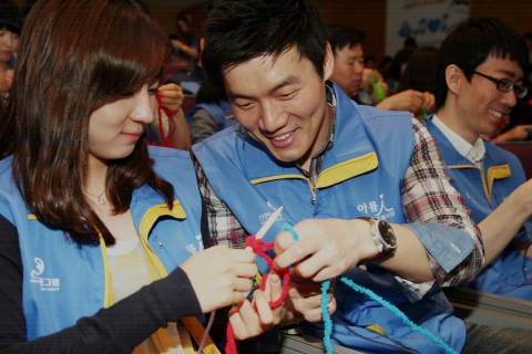 신한카드는 2013평창동계스페셜올림픽 참가 선수단에 목도리를 기증하는 '색다른 목도리 프로젝트'를 시작한다. 신한금융그룹직원들이 19일 오전, 신한금융투자 본사 대강당에서 열린 '자원봉사대축제'에서 목도리를 뜨고 있다.
