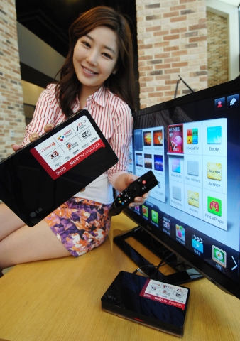 LG전자 모델이 27일 여의도 LG 트윈타워에서 일반 TV로도 스마트 기능을 사용할 수 있게 하는 스마트TV 업그레이더를 소개하고 있다.