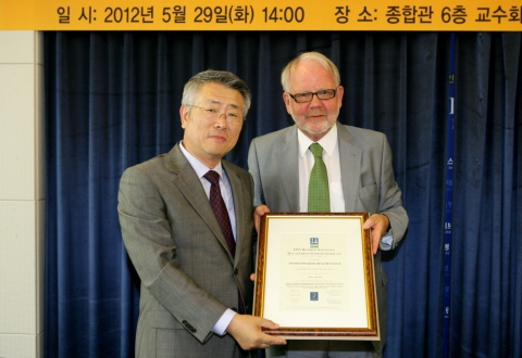 톨비요른 홀테 주한 노르웨이 대사가 이철 연세의료원장에게 인증서를 건네고 있다