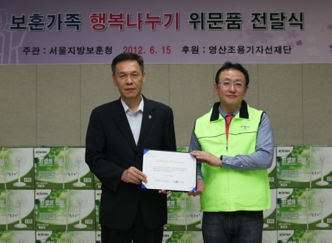 영산조용기자선재단 조희준 사무국장이 서울지방보훈청장 최완근 청장에게 기증서를 전달하고 있다