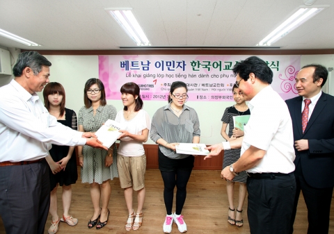 베트남 이주여성들에게 한국어교실 교재를 나누어 주고 있다.
