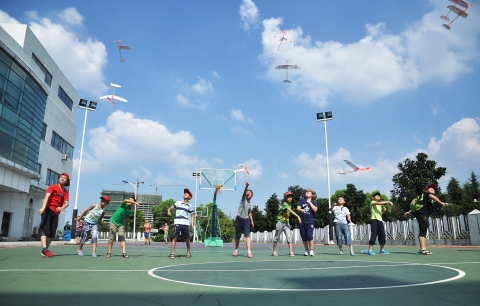 중국 우시지역 어린이 초청 행사에서 만든 고무 동력 모형 비행기를 날리고 있다.