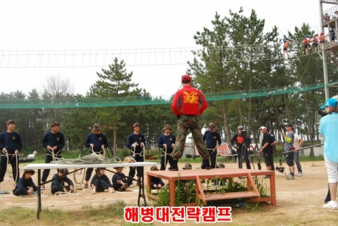 해병대캠프 프로그램에 참가한 아빠와 아들 여섯가족이 유격훈련 레펠과 줄타기훈련에 앞서 교관으로부터 매듭법 교육을 받고있다. (사진=해병대전략캠프 제공)