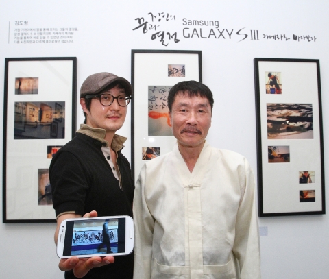삼성전자가 7일 세종문화회관 전시관 1에서 개최한 &#039;장인의 꿈과 열정 갤럭시SⅢ 카메라로 바라보다&#039; 사진전에서 전시에 참여한 김도형 작가(왼쪽)와 석창우 화백이 함께 포즈를 취하고 있다.