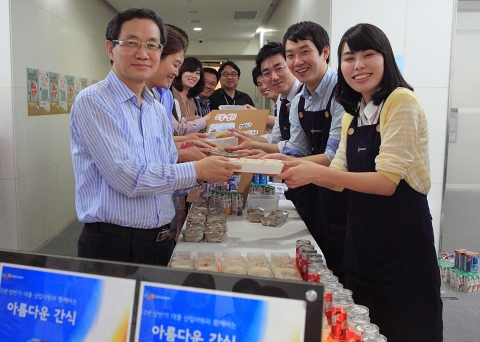 CJ프레시웨이 박승환 대표(사진 좌)와 직원들이 신입사원들로부터 구매한 간식을 건네 받고 있다. 이 수익금은 전액 CJ의 대표 사회공헌 프로그램인 ‘도너스 캠프’에 기부될 예정이다