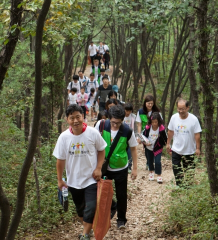 동화홀딩스 임직원과 인천 서구 지역 아이들 등 50여명이 인천 원적산 둘레길을 걸으며 환경정화 활동을 겸한 ‘그린켐페인’을 펼치고 있다.