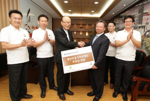 영산조용기자선재단 조용기 이사장(왼쪽)에게 영남제분주식회사 류원기 대표(오른쪽)가 후원금을 전달하고 있다