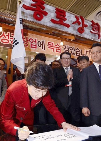 코엑스에서 열린 ‘4060 인생설계 박람회’의 종로상회 부스를 방문한 박근혜 새누리당 대선후보가 방명록을 작성하고 있다.