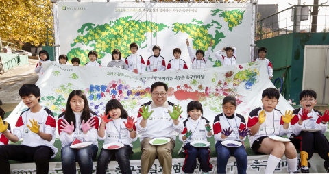 한국암웨이 ‘뉴트리라이트 축구교실과 함께 하는 지구촌 축구한마당’에서 한국암웨이 노원호 상무와 (첫째줄 중앙) ‘뉴트리라이트 축구 교실’ 어린이들이 다문화 축구팀 창단을 기념하며 