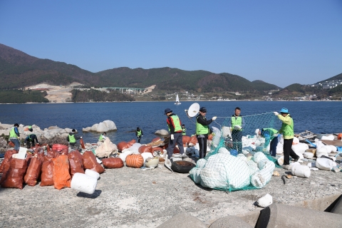 대우조선해양 봉사 단원들이 지세포 일대 선창마을 방파제에서 환경정화 활동을 하고 있다.