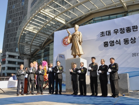 참석자들이 홍영식 동상앞에서 기념촬영을 하고 있다.(왼쪽 다섯 번째 홍석우 장관, 여섯 번째 김명룡 우정사업본부장, 열 번째 이승재 서울지방우정청장)