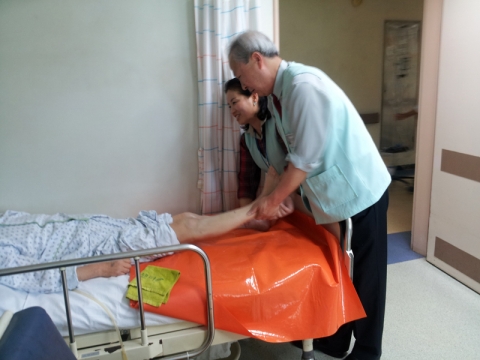 몸이 불편한 환자의 머리 감기기와 발마사지 봉사를 담당하는 곽노숙씨 자원봉사 팀의 모습