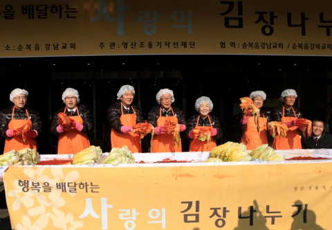 직접 담근 김치를 들어 보이고 있다(왼쪽부터 하남교회 임동환 목사, 성산순복음교회 송영준 목사, 순복음강남교회 최명우 목사, 자선재단 조용기 이사장, 김성혜 이사장, 김창대 고문, 주거복지재단 이윤재 대표, 중증장애인독립생활연대 윤두선 대표).
