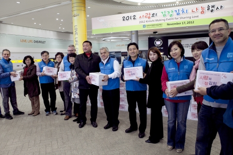 한국지엠 세르지오 호샤 사장(오른쪽에서 여섯번째)과 임원들이 인천시 사회복지기관 관계자들에게 이날 담근 김치를 전달하고 있다.