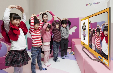 삼성전자 모델들이 삼성 스마트 TV의 '버추얼 미러' 기능을 활용한 '킨더가든' 콘텐츠를 이용해 영어 단어와 율동을 배우고 있다.