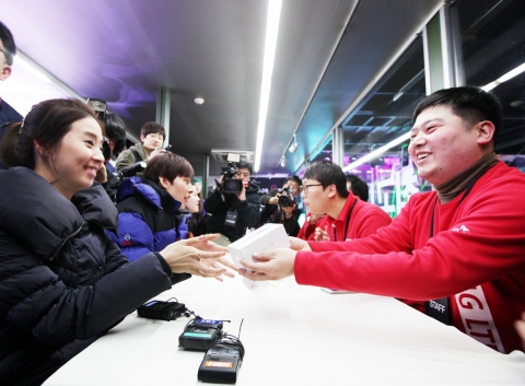 7일 0시 SK텔레콤 아이폰5 국내 최초 개통 행사에서, 1호 가입자 안혜진(28세/사진 왼쪽) 씨가 아이폰5를 건네받고 있다.