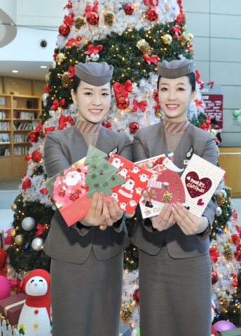 아시아나항공이 지난 여름 탑승객들이 기내에서 직접 작성한 크리스마스 카드와 편지를 크리스마스에 맞춰 배달하는 &#039;오즈 러브레터&#039;서비스를 실시하고 있다. 아시아나항공 승무원들이 탑승객들이 작성한 카드를 들어보이고 있다.