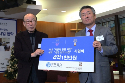 영산조용기자선재단 이사장 조용기 목사가 연세의료원 이 철 의료원장에게 2차분 국내․해외 사업비 4억 1천만 원을 전달하고 있다.