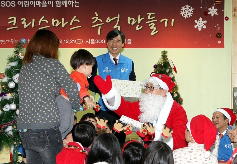 신한은행 임직원들이 몰래 산타가 되어 지역아동센터 아이들에게 선물을 전달하며 즐거운 시간을 가지는 모습.