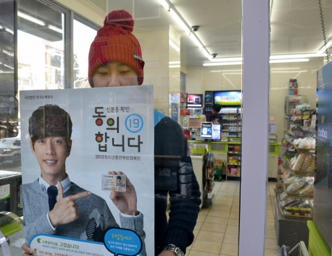 ‘청소년흡연예방캠페인’ 대학생 서포터즈가 9일 서울 서대문구 충정로의 한 편의점에 담배 구입 시 신분증을 제시하고 확인하는 절차를 생활화해 청소년 흡연을 미연에 예방하자는 내용의 포스터를 부착하고 있다.