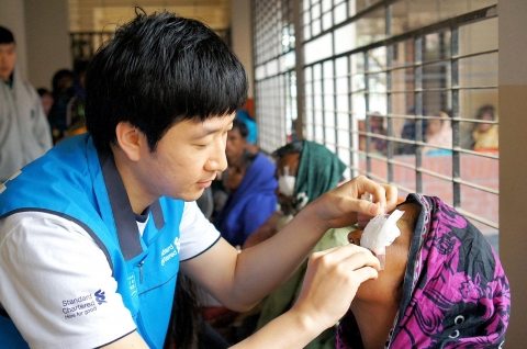 한국스탠다드차타드금융그룹의 해외안과의료봉사단인 ‘아이캠프(Eye Camp)원정대’와 국제실명구호단체인 비전케어가 방글라데시 사바 지역에서 개안수술 및 안과진료 봉사활동을 실시했다. 한국스탠다드차타드은행 직원 봉사자가 백내장 수술을 받은 방글라데시 환자의 수술 후 처리를 돕고 있다. ‘아이캠프원정대’는 예방가능한 실명퇴치를 위해 스탠다드차타드가 진행하고 있는 Seeing is Believing 캠페인 일환인 지속가능경영활동이다.