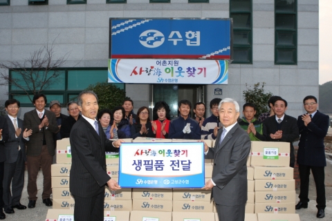 이주형 수협은행장이 고성군수협 황월식 조합장에게 어려운 이웃을 위한 생필품을 전달하고 있다.